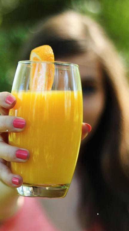 Fresh juice held beside a juicer demonstration